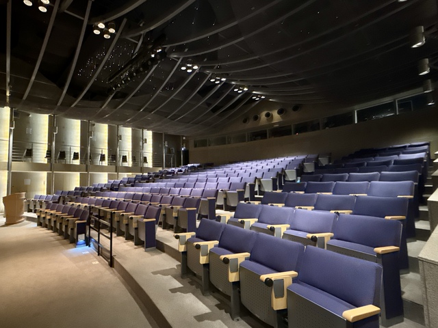 Blue chairs of the auditorium seen from the entrance